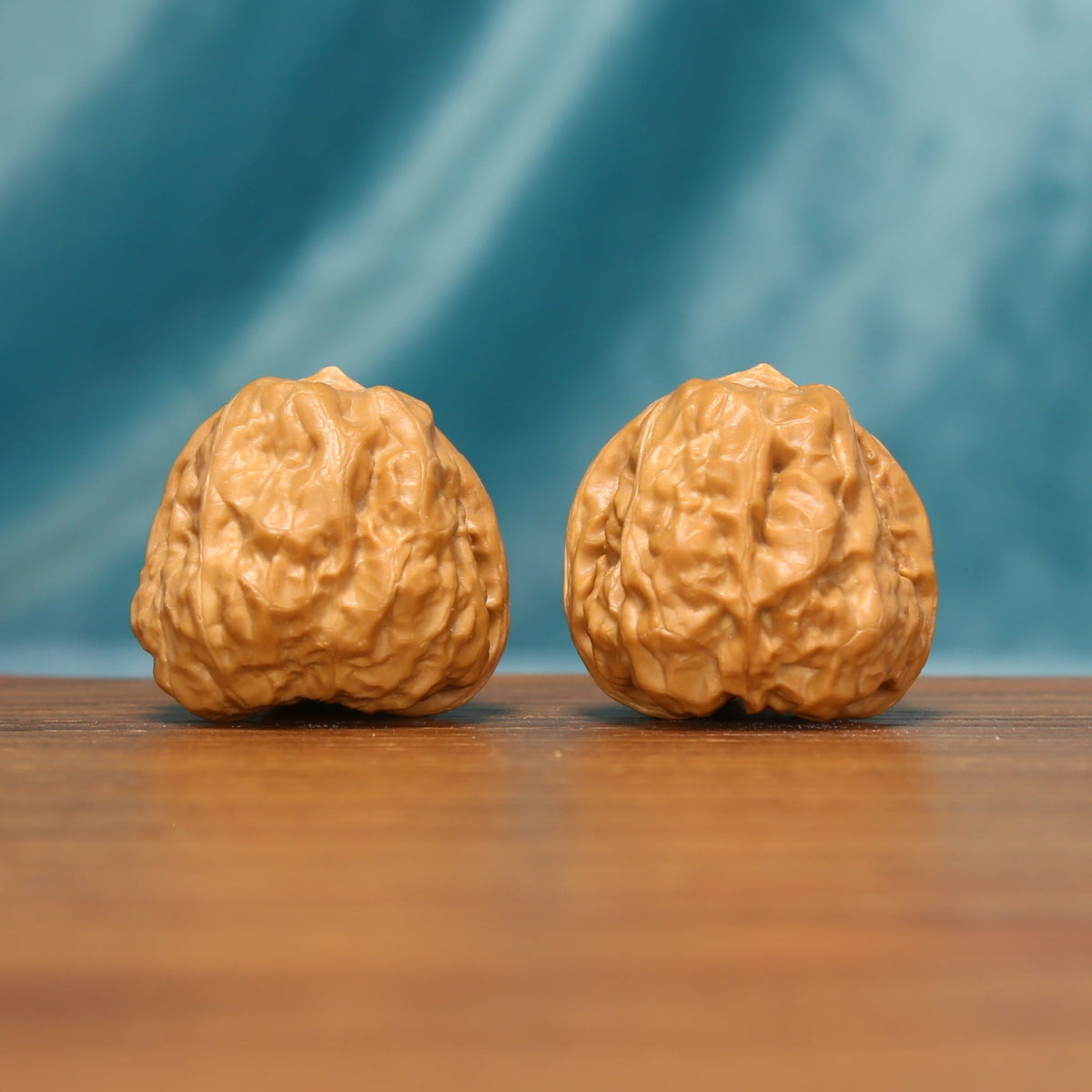 Angled front view of The Ridge Lanterns Wenwan walnuts highlighting their rounded forms and intricate ridge patterns.
