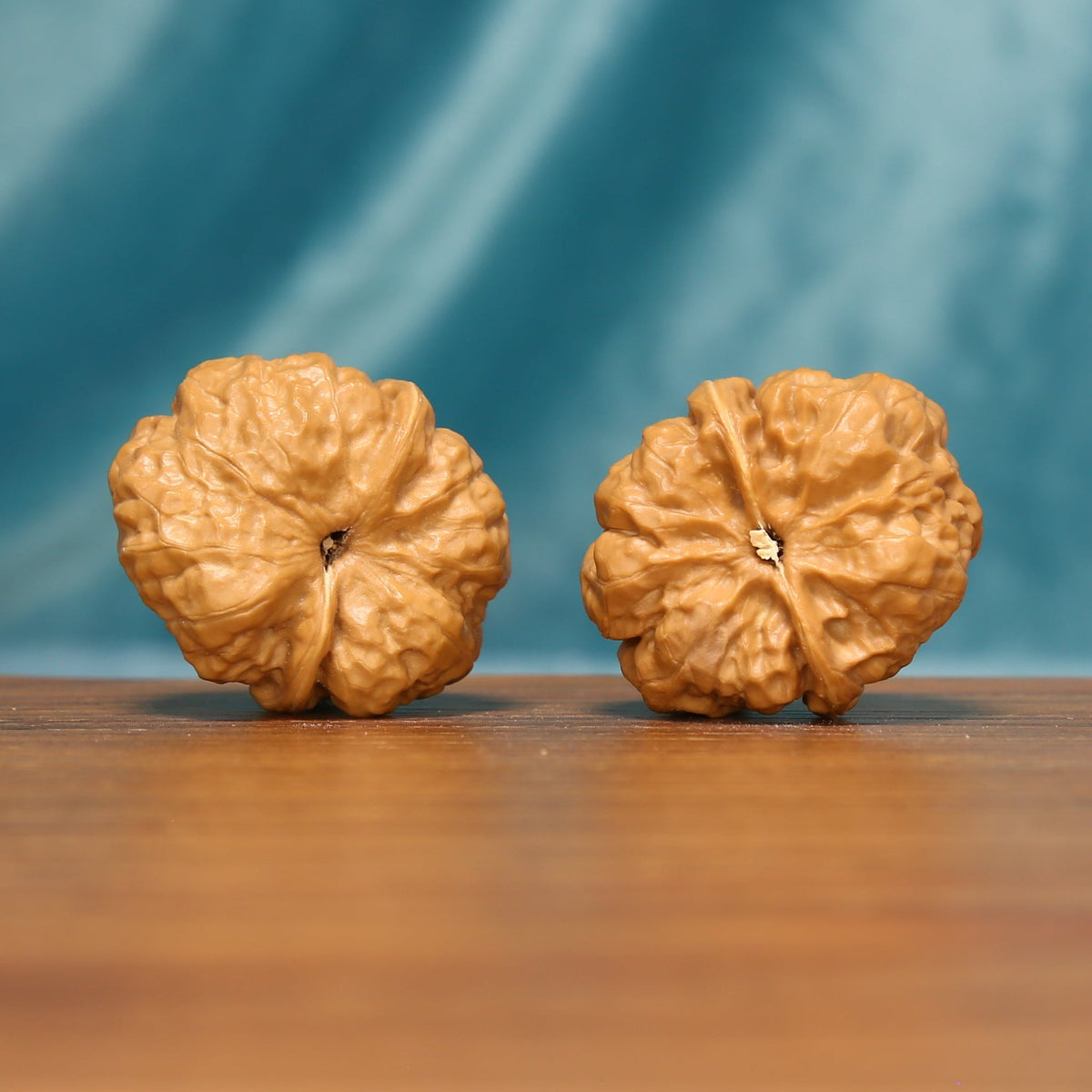 Rear view of The Ridge Lanterns Wenwan walnuts displaying their sculpted surfaces and distinctive natural ridges.
