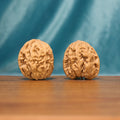 Front view of a Lion Head Wenwan walnut pair with broad rounded forms and dense natural ridges.
