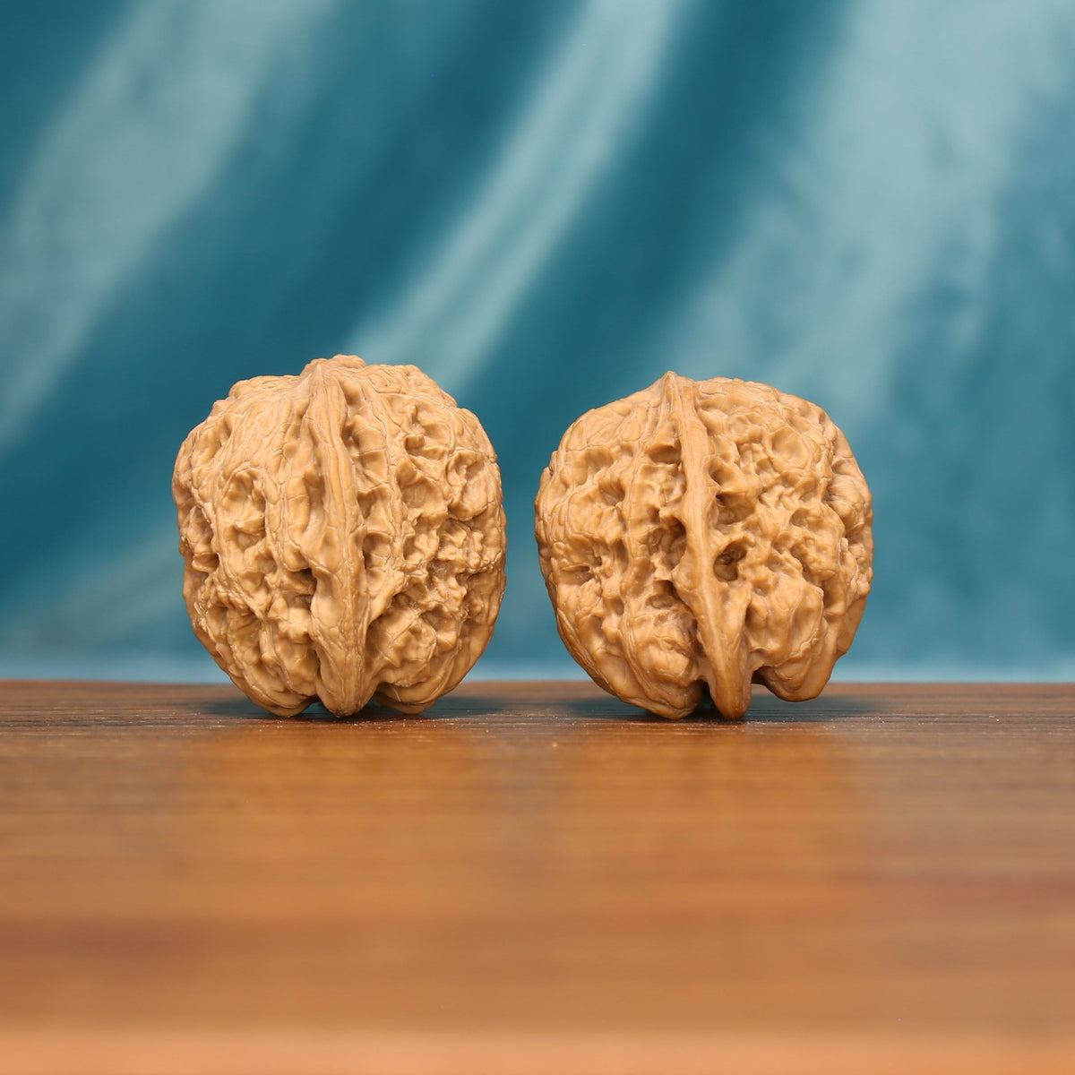 Side view of a Lion Head Wenwan walnut pair with deep ridges and full rounded profiles.
