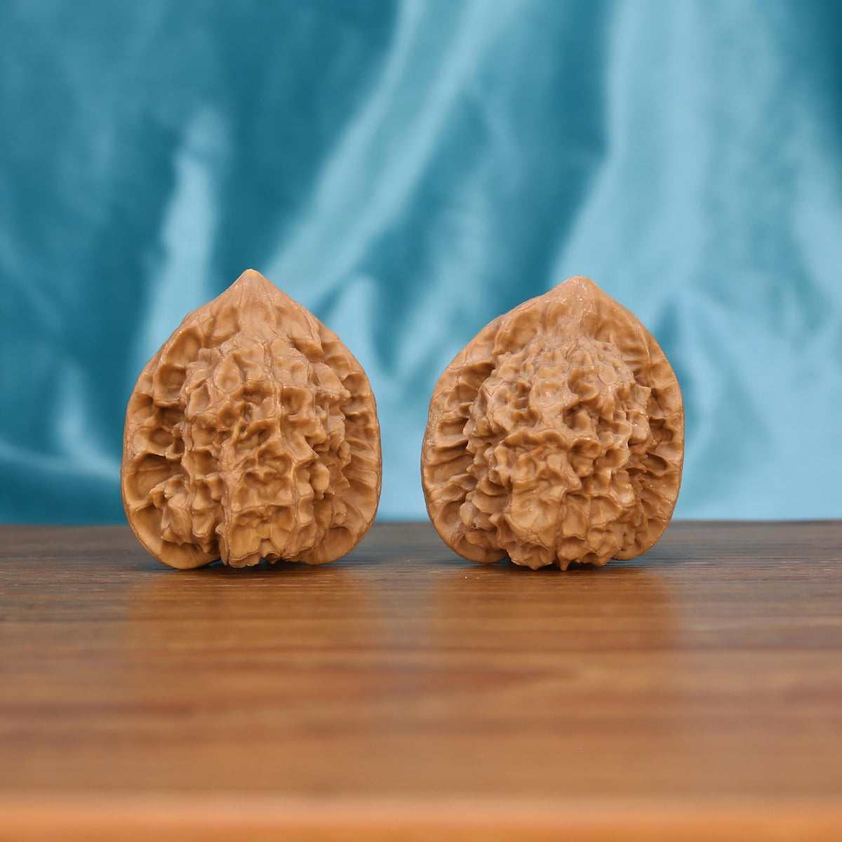 Qi-Lin-Wen Guan-Mao walnut duo on wooden surface – 27g dense botanical spheres by mistbodhi