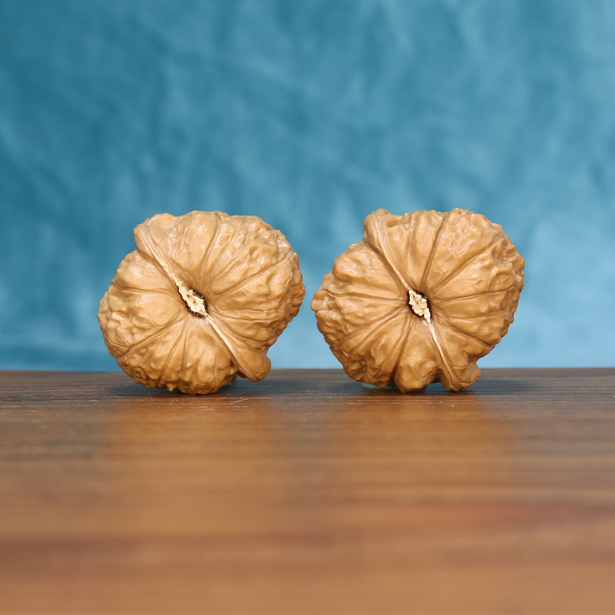 Top view of the pumpkin wenwan walnut pair 6211, showing the star-shaped ridged crown of each walnut
