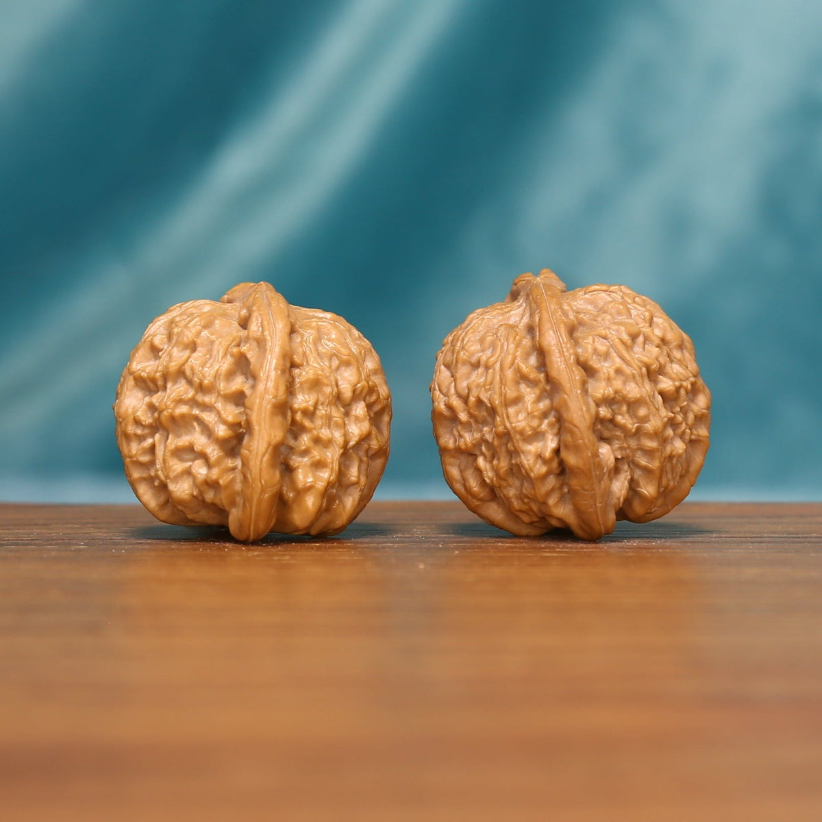 Side view of a Tiger Head Wenwan walnut pair highlighting the deep ridges and sculptural forms.

