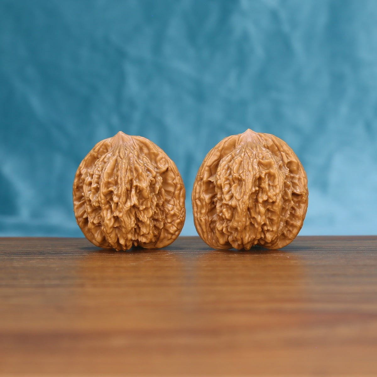 Front view of a matched pair of Wheat Tiger Wenwan walnuts with bold natural ridges
