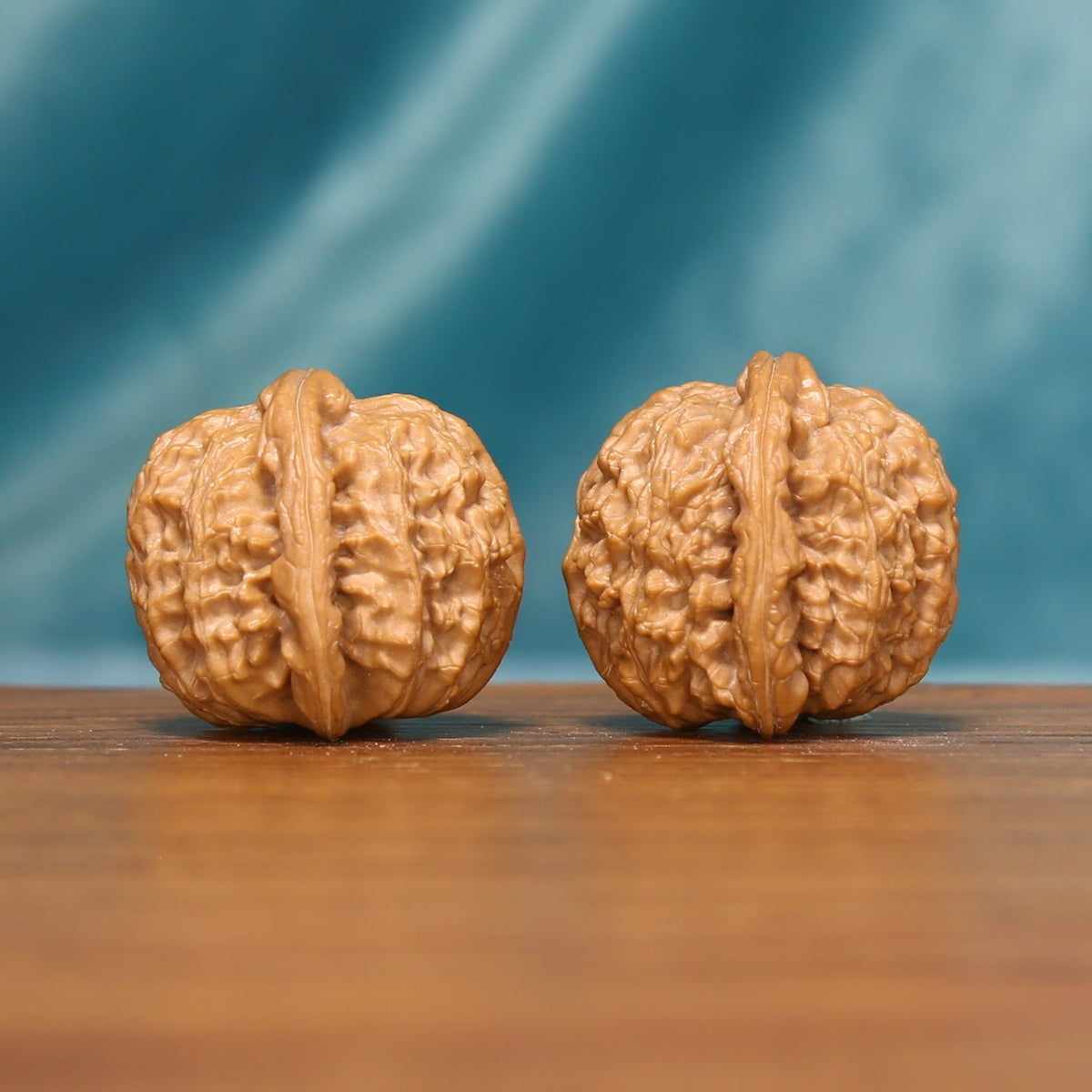 Detailed side view of Tiger Head Wenwan walnuts with pronounced natural ridges and compact rounded shapes.
