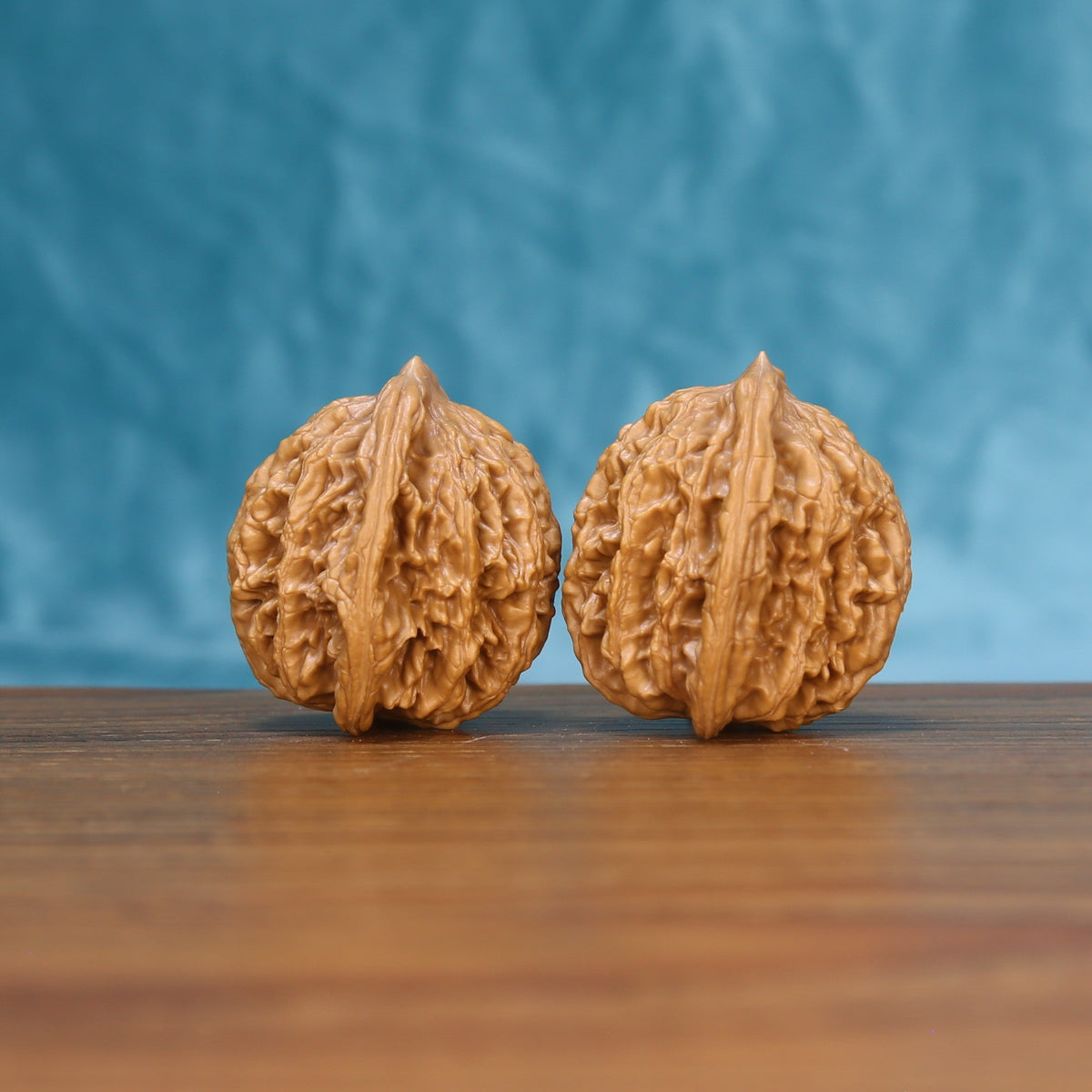 Three-quarter view of two Wheat Tiger Wenwan walnuts showing textured shells
