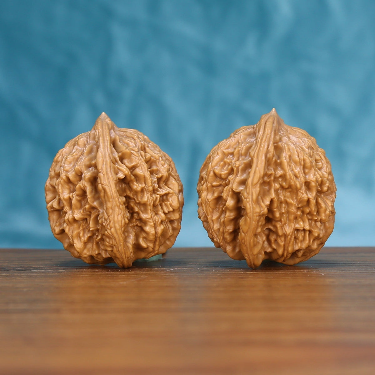 Side view of a Wheat Tiger Wenwan walnut pair on a wooden surface
