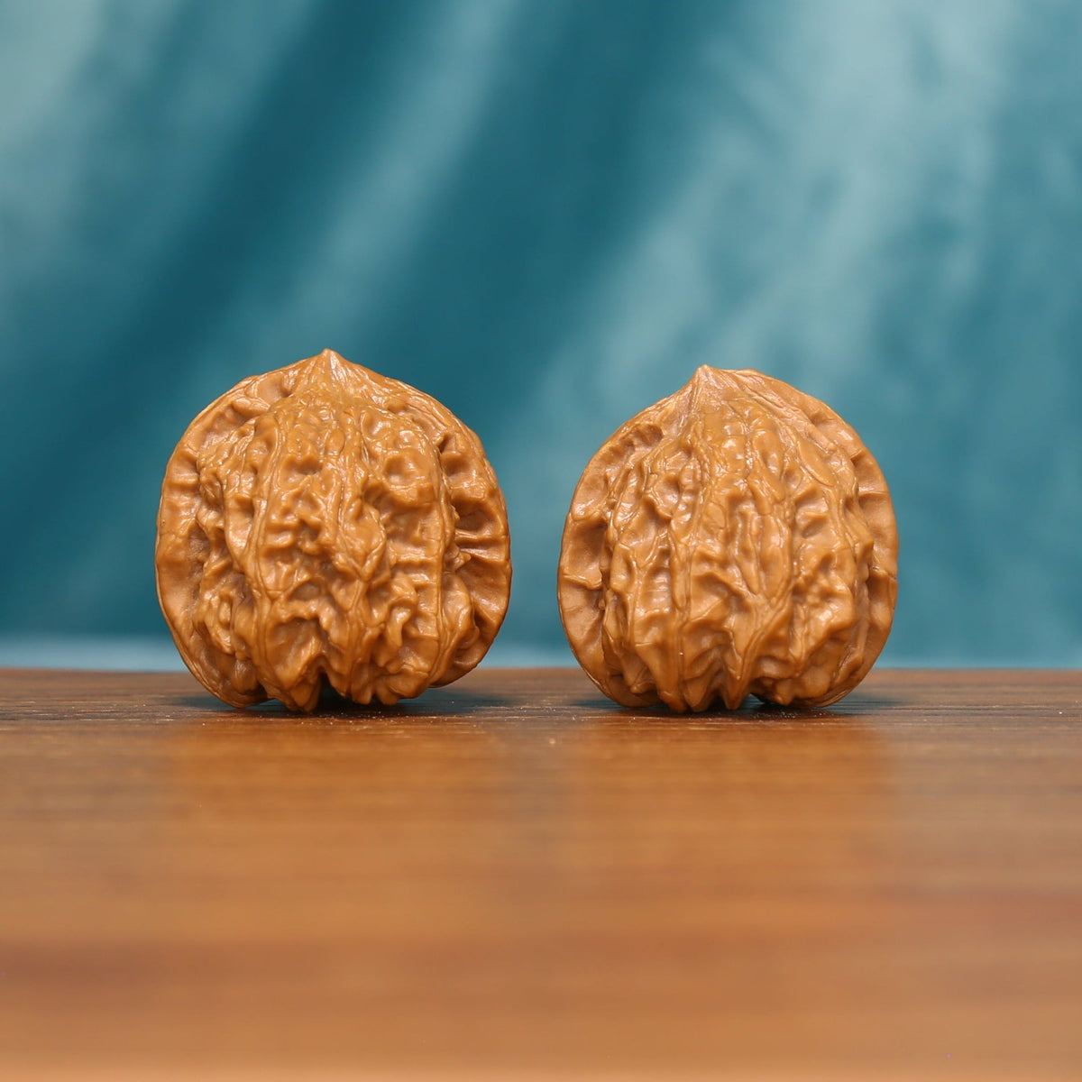 Angled front view of Honeycomb Lion Head Wenwan walnuts showing their warm color and intricate ridges.
