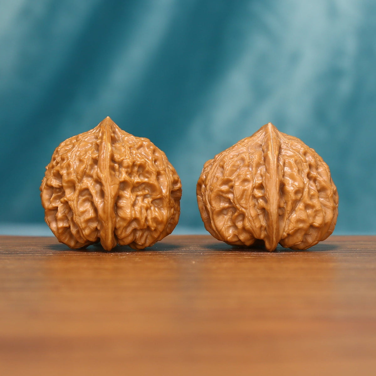Side view of a Honeycomb Lion Head Wenwan walnut pair with compact shapes and deep natural texture.
