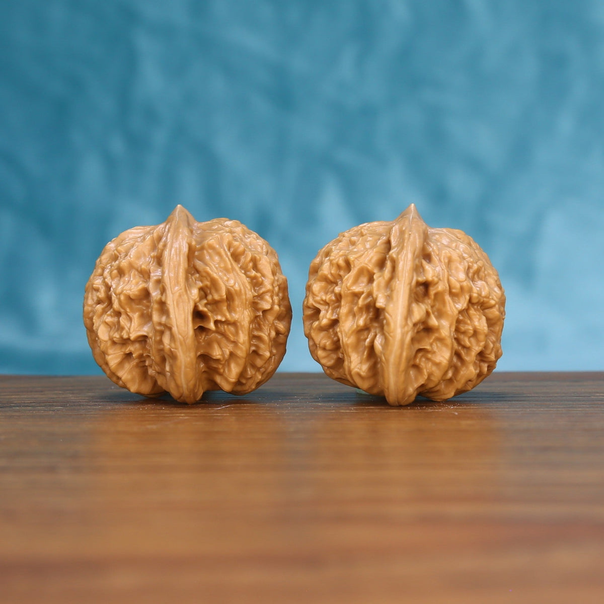 Three-quarter view of two Coiling Dragon Wenwan walnuts showing detailed shell texture
