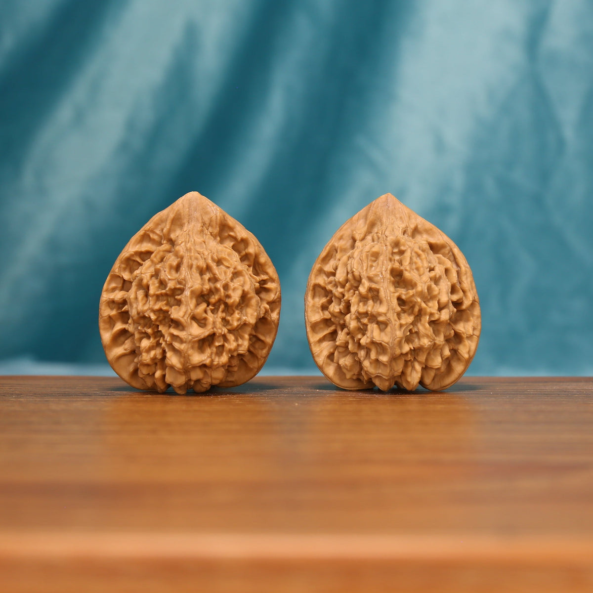 L22 Wenwan walnut matched pair displayed side by side on a wooden surface against a teal background.
