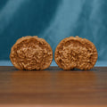 Pair of 1715 wenwan walnuts resting on their sides, showing textured rounded ends
