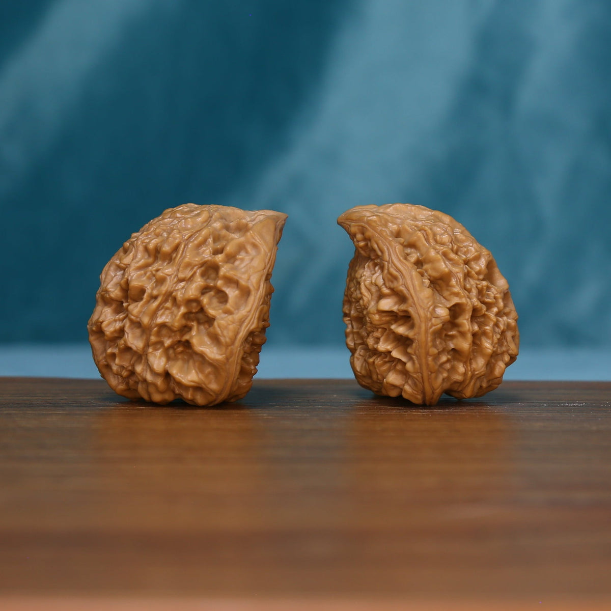 Pair of 1715 wenwan walnuts resting on their sides, showing textured rounded ends
