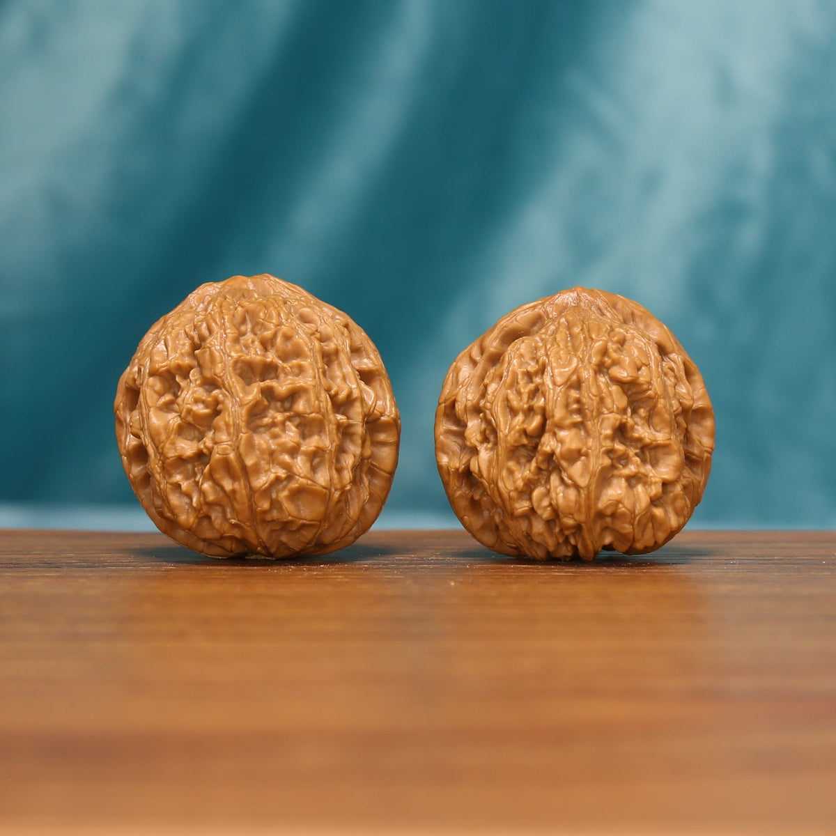 The Emberstone Twins L37 wenwan walnut pair standing upright on a wooden surface
