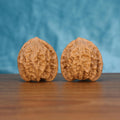 Two Long-Ji wenwan walnuts on wooden surface, blue fabric background – matching mythic spine set
