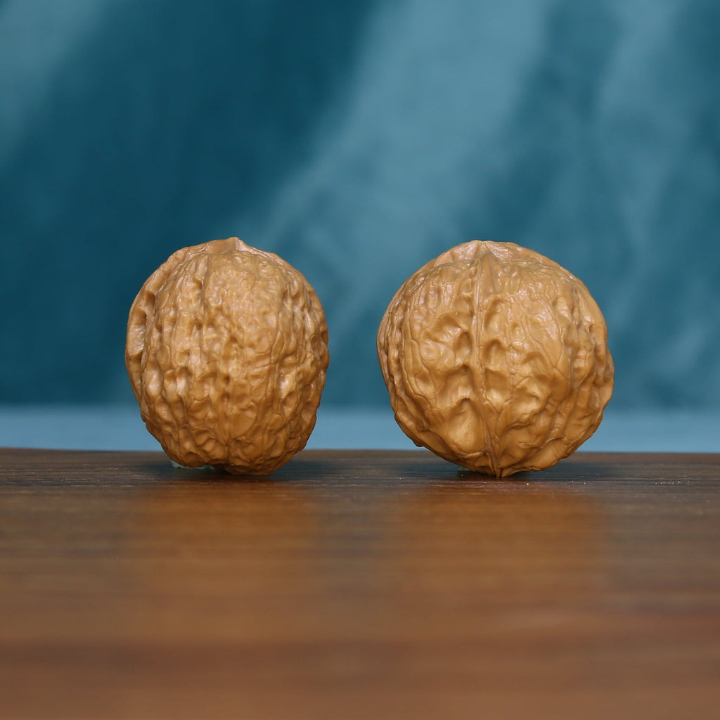 Front view of two S1314 Iron-Skin Three-Ridge wenwan walnuts with distinct surface grooves
