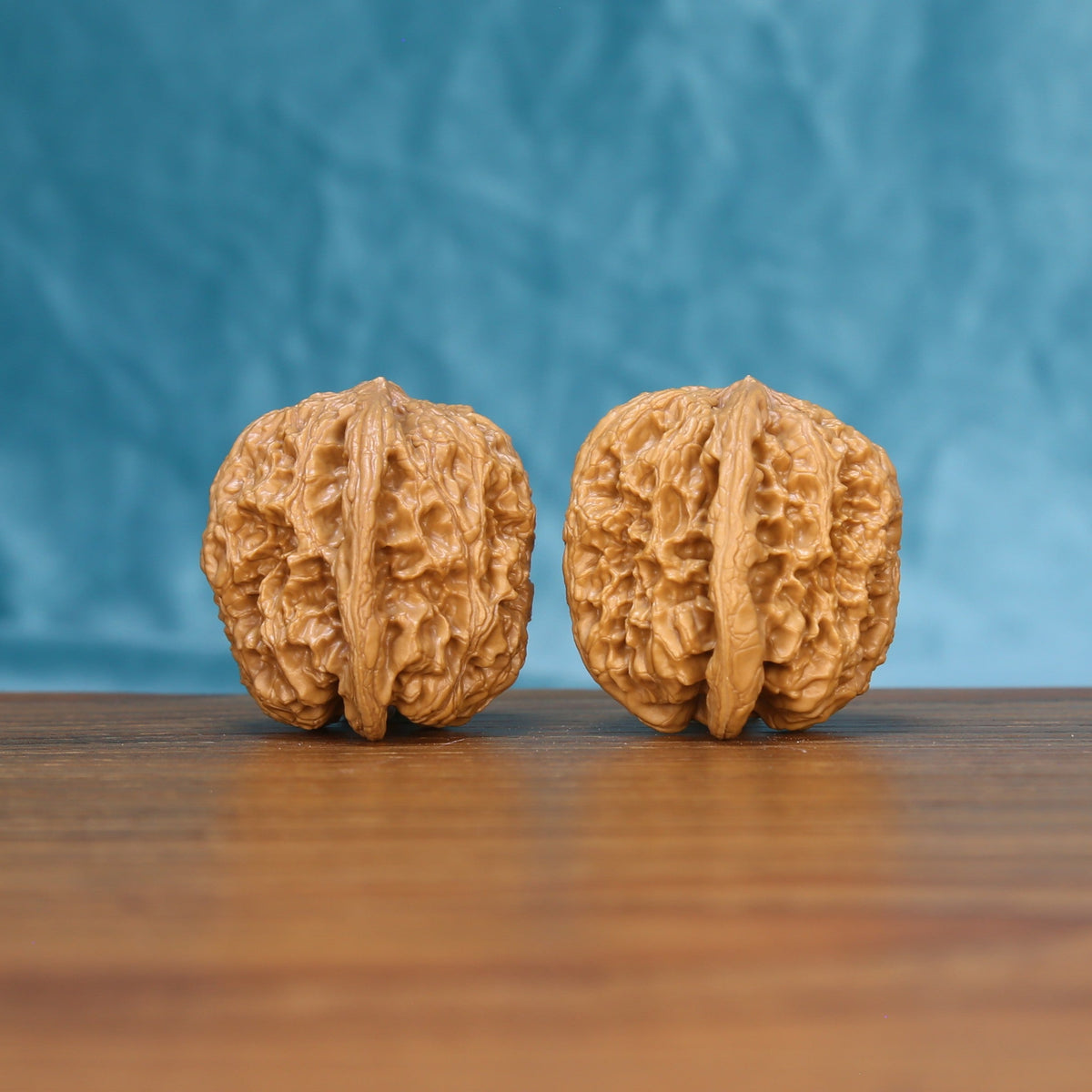 Three-quarter view of two General Wenwan walnuts showing deep sculptural ridges
