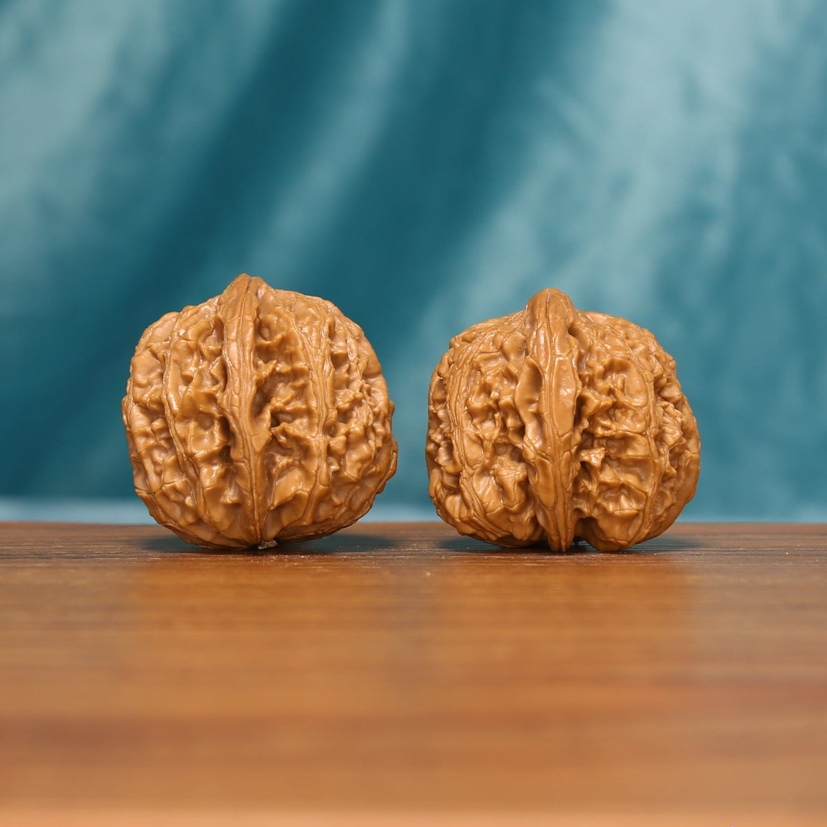 The Emberstone Twins L37 wenwan walnuts, angled view of the carved surface

