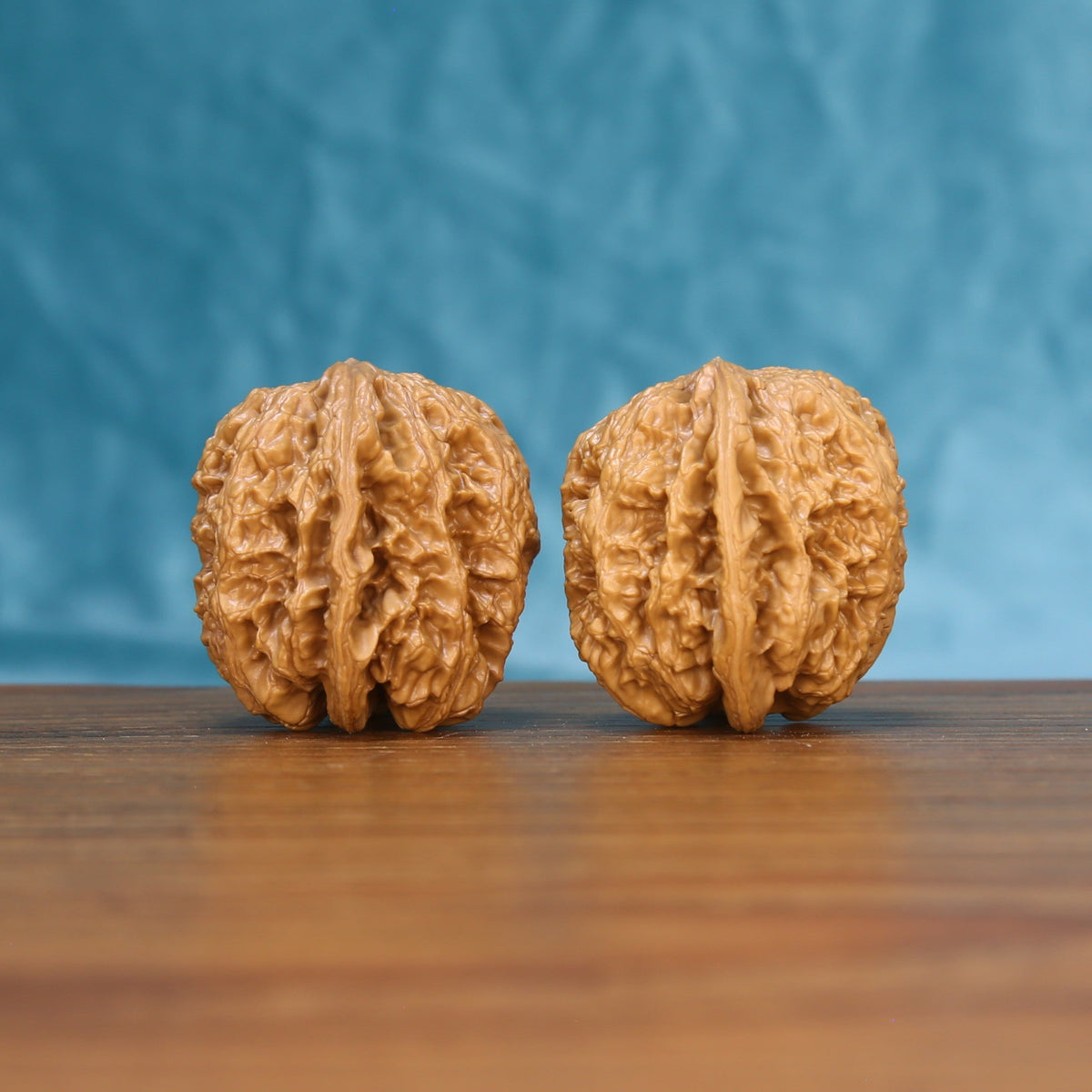 Side view of a General Wenwan walnut pair on a wooden surface

