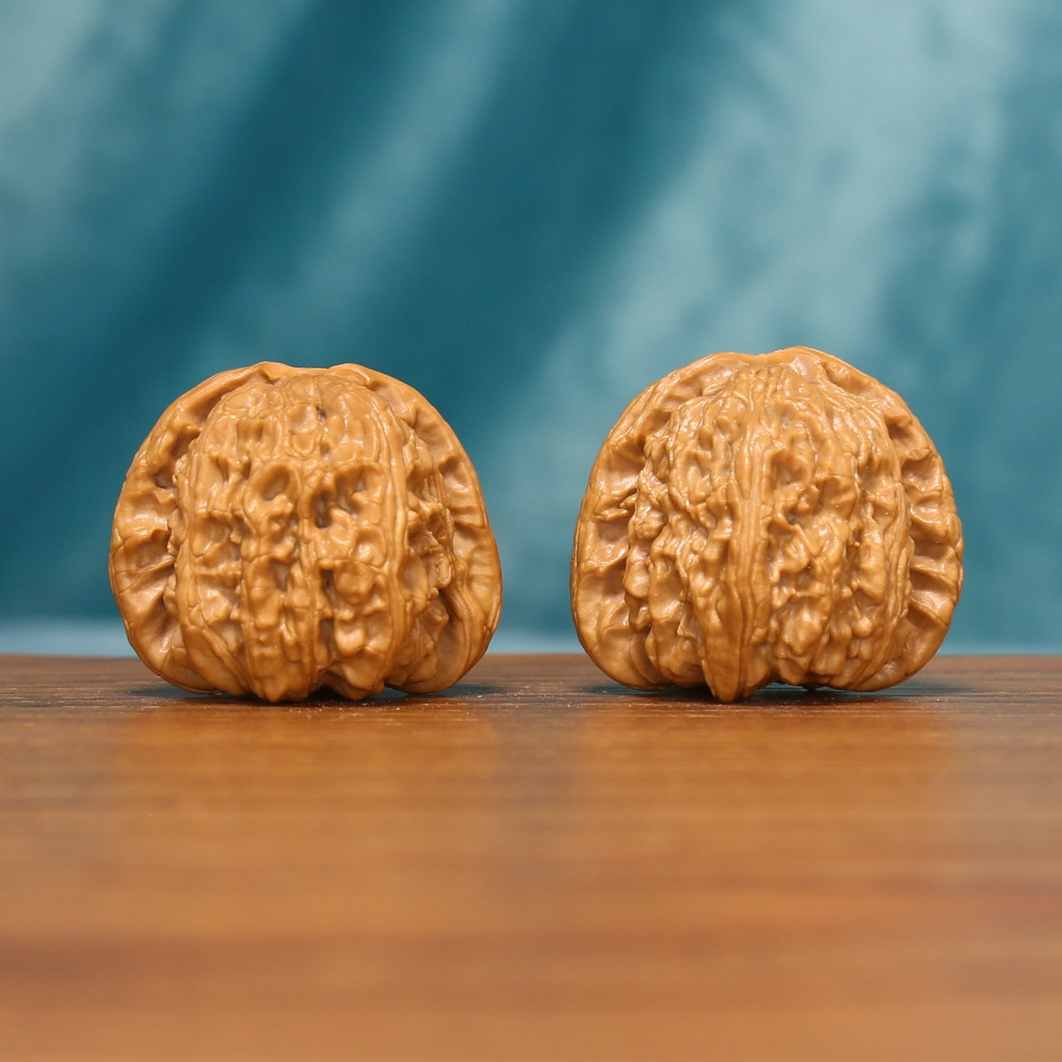 Front view of The Golden Basin Wenwan Walnut Set with two low-profile rounded walnuts and dense natural ridges.
