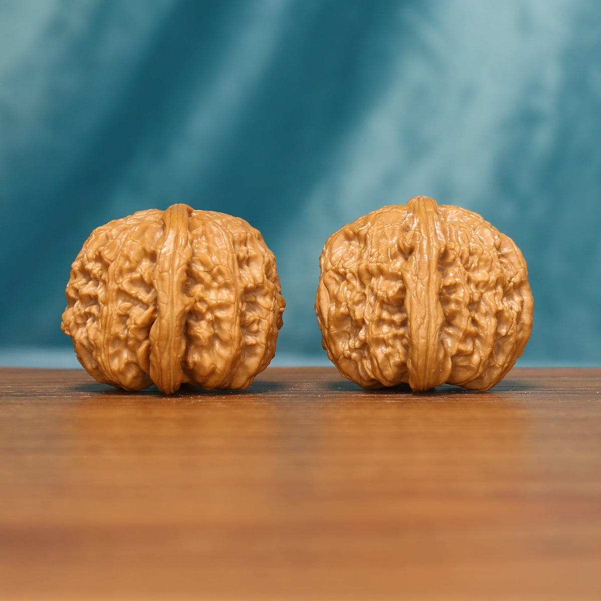 Detailed side view of The Golden Basin Wenwan Walnut Set with broad profiles and intricate ridge patterns.
