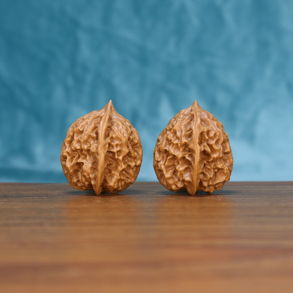 Three-quarter view of two Linglong Wenwan walnuts showing detailed natural ridges
