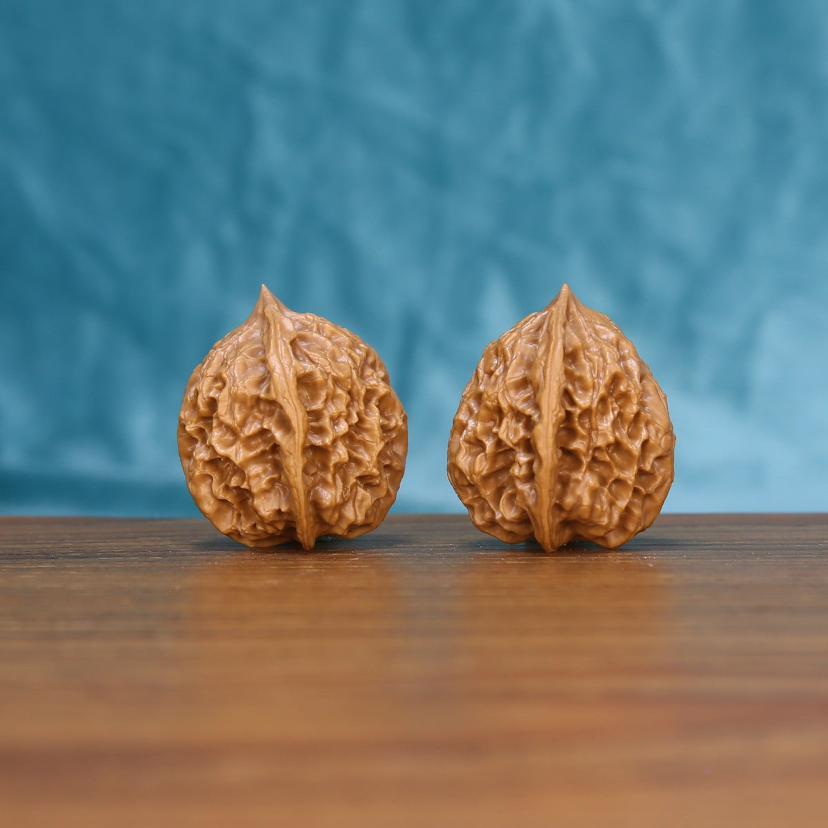 Side view of a Linglong Wenwan walnut pair on a wooden surface
