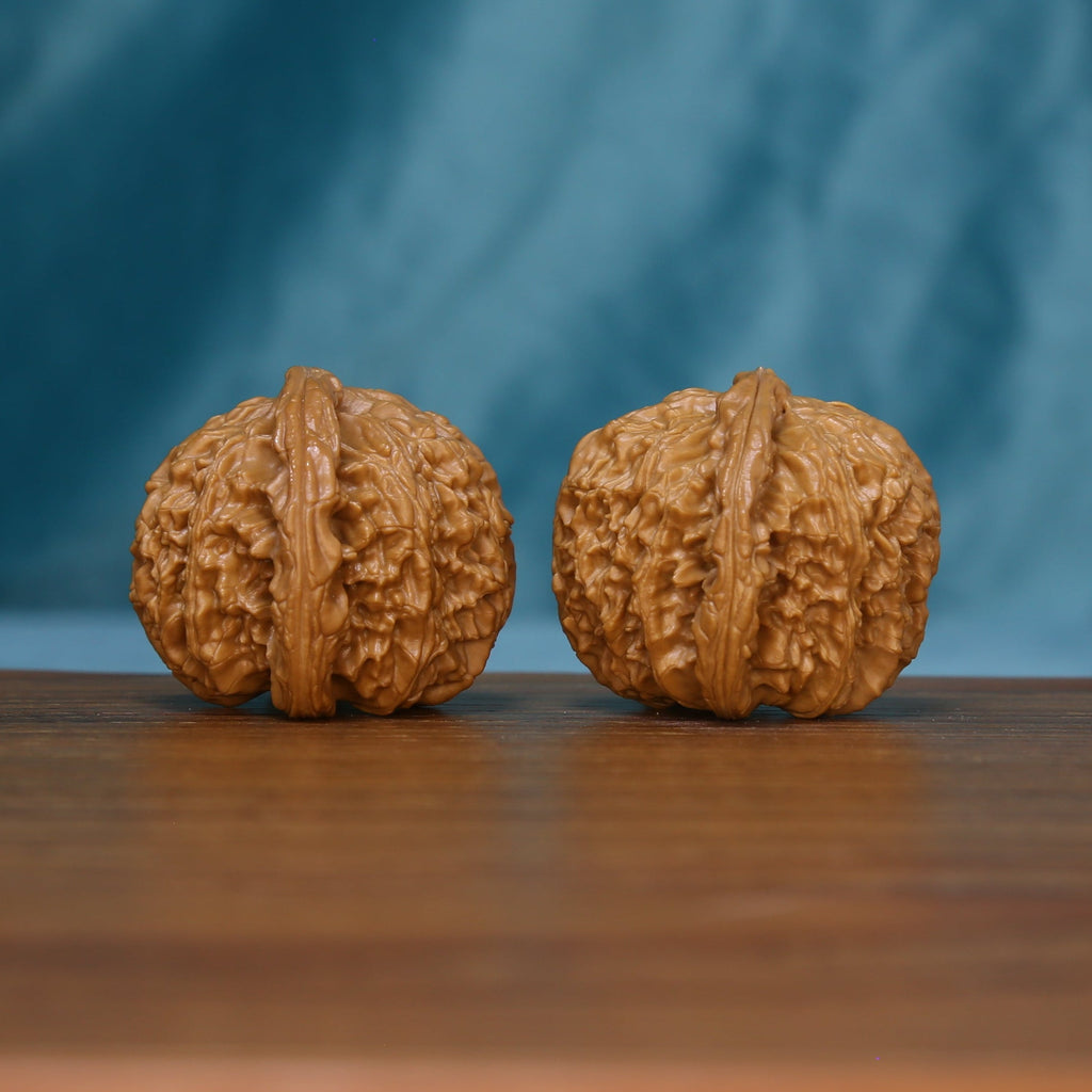 Side view of two S46 White Lion wenwan walnuts with pronounced ridges
