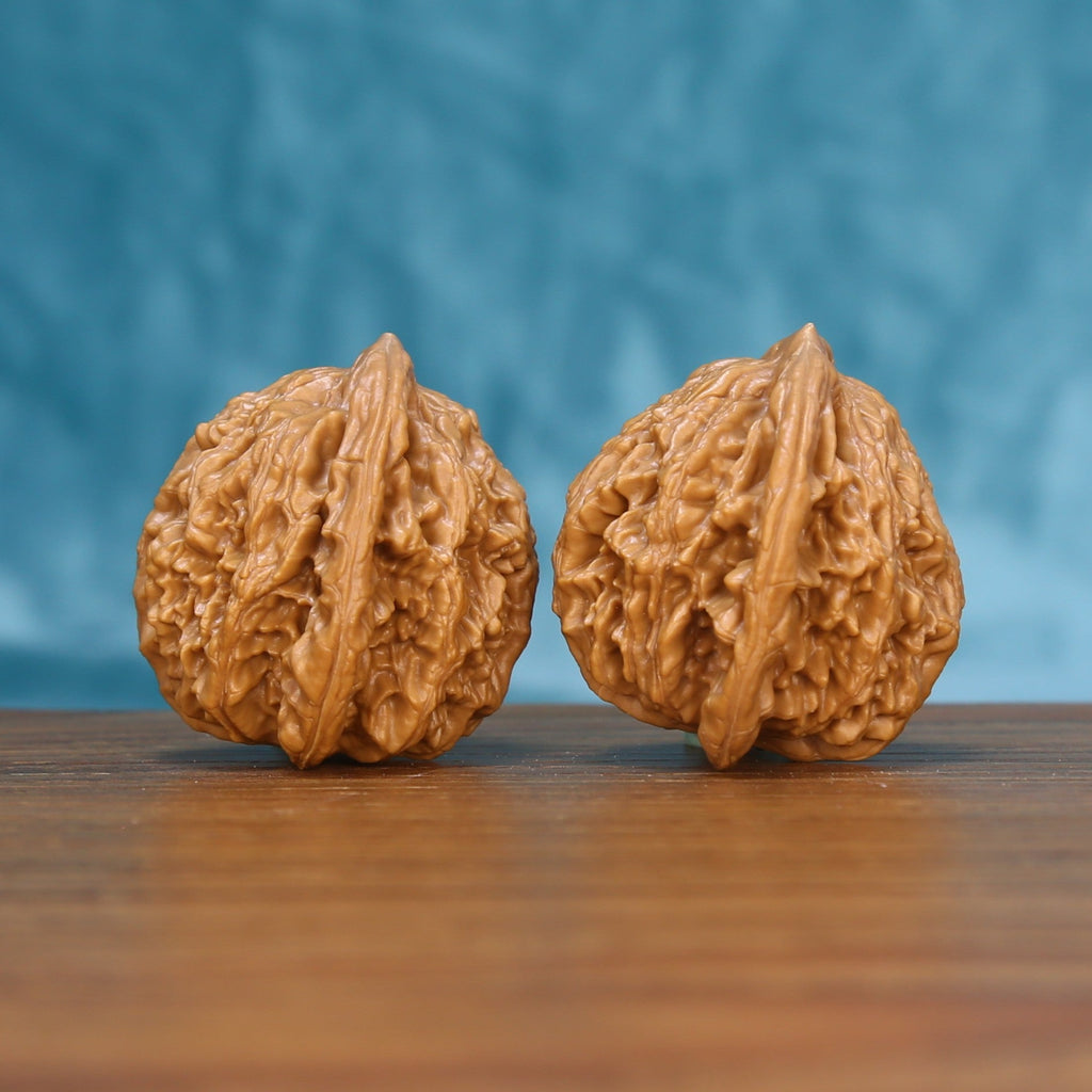 Close view of two matched Wheat Tiger wenwan walnuts showing deep ridges and warm natural grain
