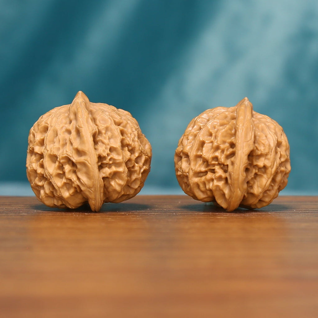 L20 Wenwan walnut matched pair shown from an angled front view, displaying detailed ridges and textured shells.
