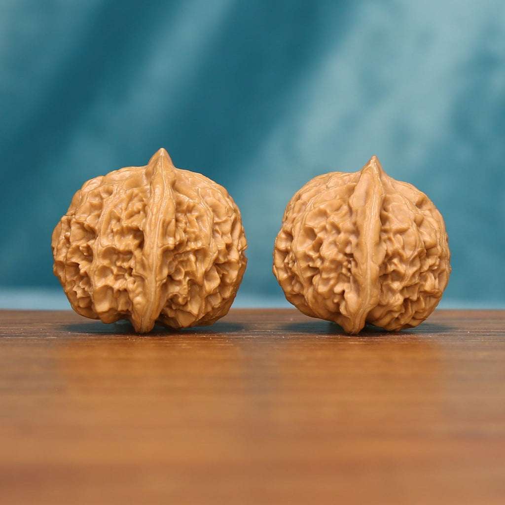 L20 Wenwan walnuts shown side by side from another frontal angle, highlighting their natural grooves and individual texture.
