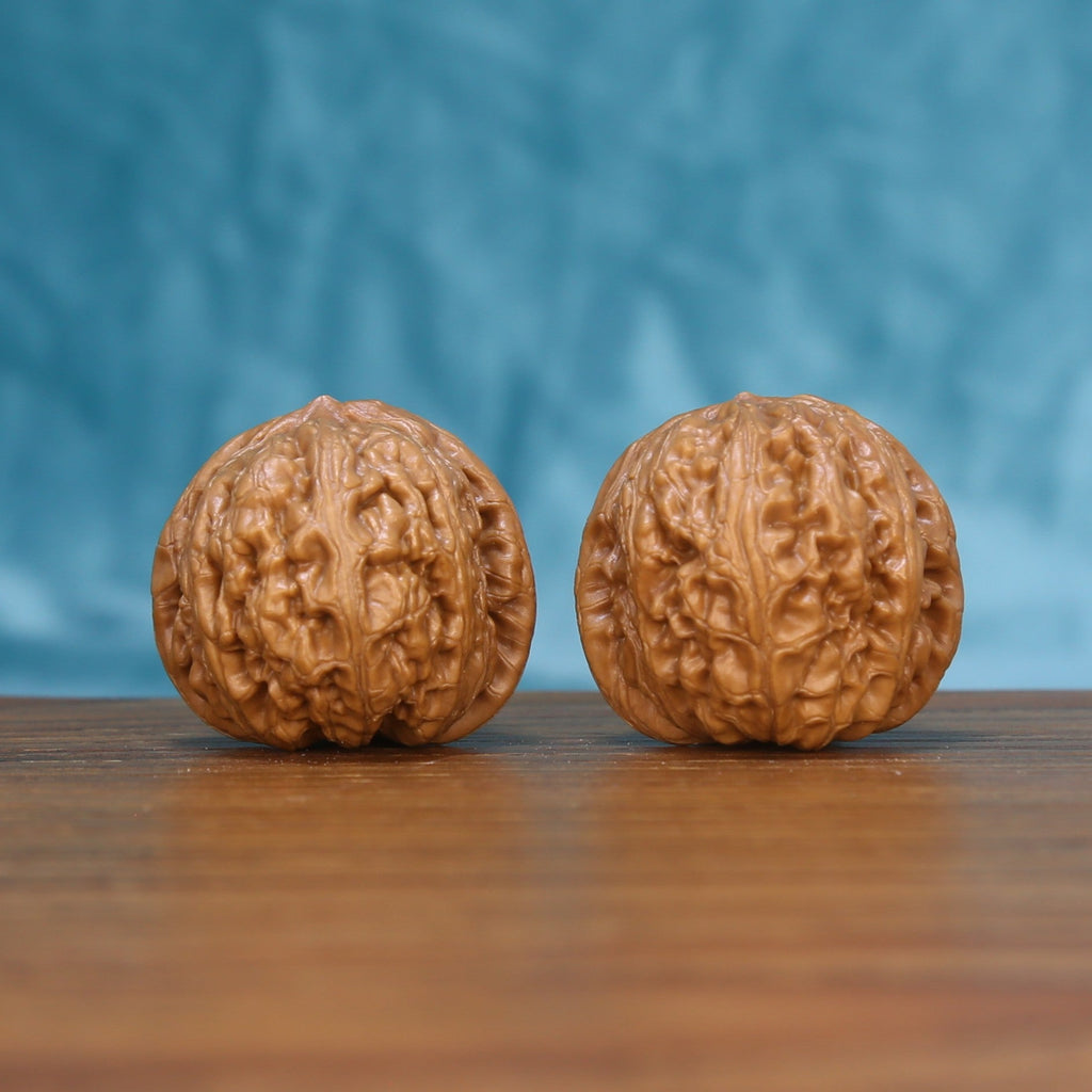 Front view of a matched pair of Pinggu Yuanbao Wenwan walnuts with rounded natural texture
