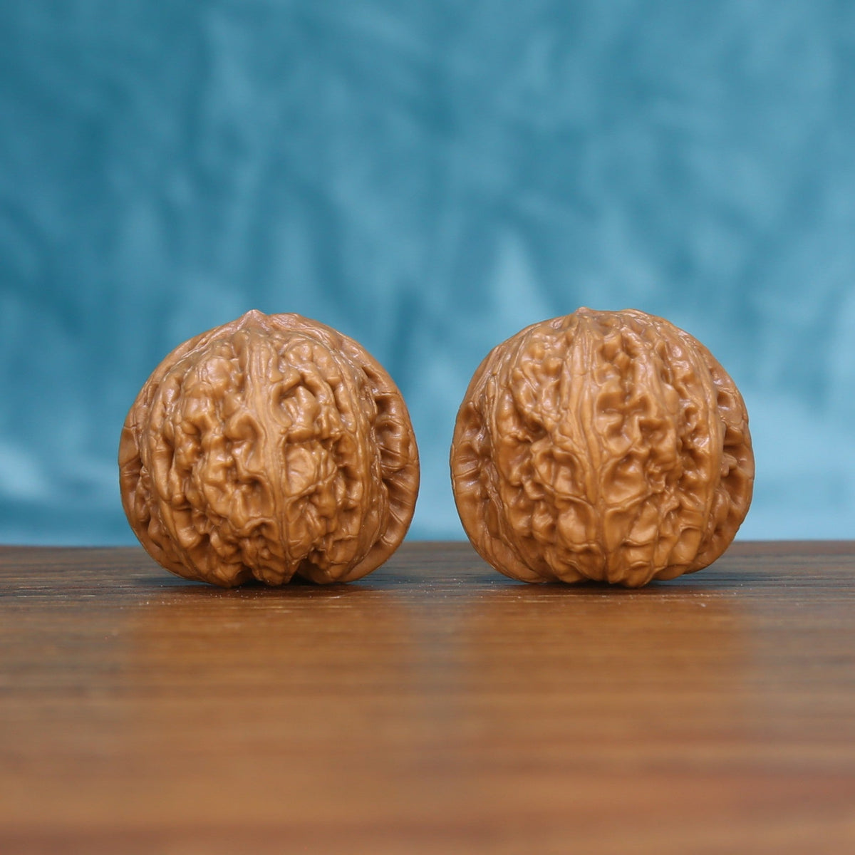 Front view of a matched pair of Pinggu Yuanbao Wenwan walnuts with rounded natural texture
