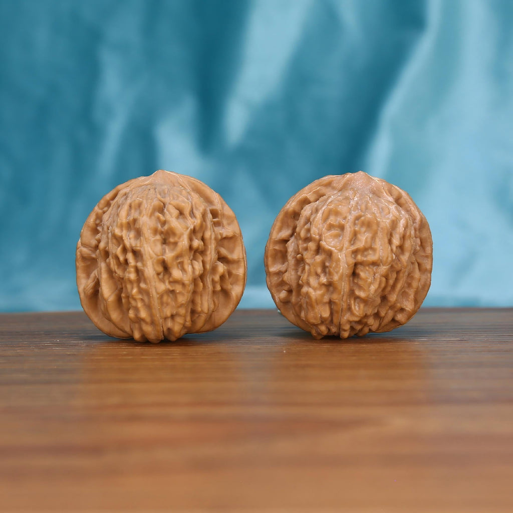 Si-Zuo-Lou walnut pair on stone slab – near-perfect 0.3g symmetric rotation botanical spheres
