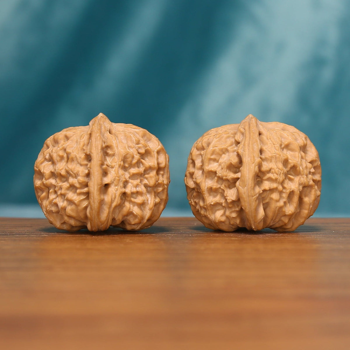 Side view of The Ivory Lion Wenwan Walnut Set showing the walnuts’ rounded profiles and intricate textured surfaces.
