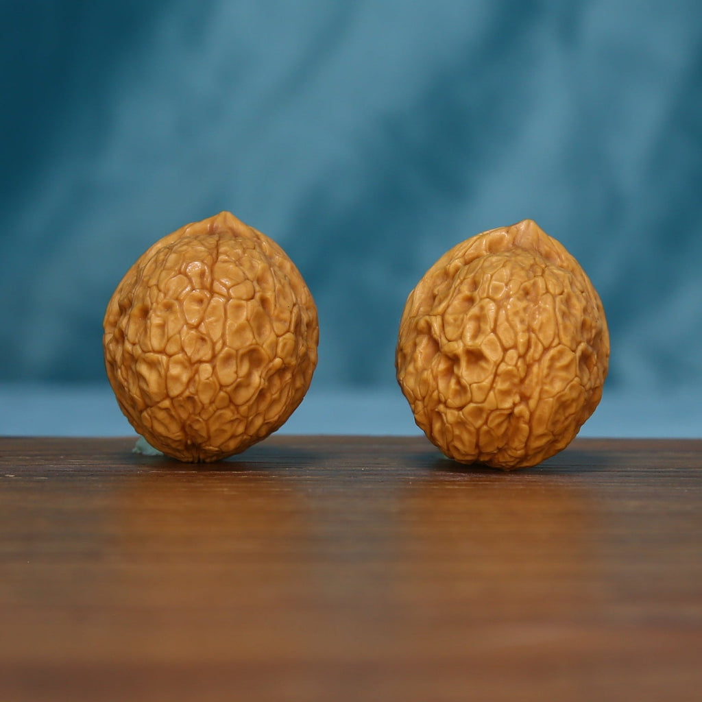 Side view of two 163 wenwan walnuts with rounded profiles
