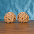 Two Bai-Shi-Zi wenwan walnuts on wooden surface, blue fabric background – matching alabaster mane set