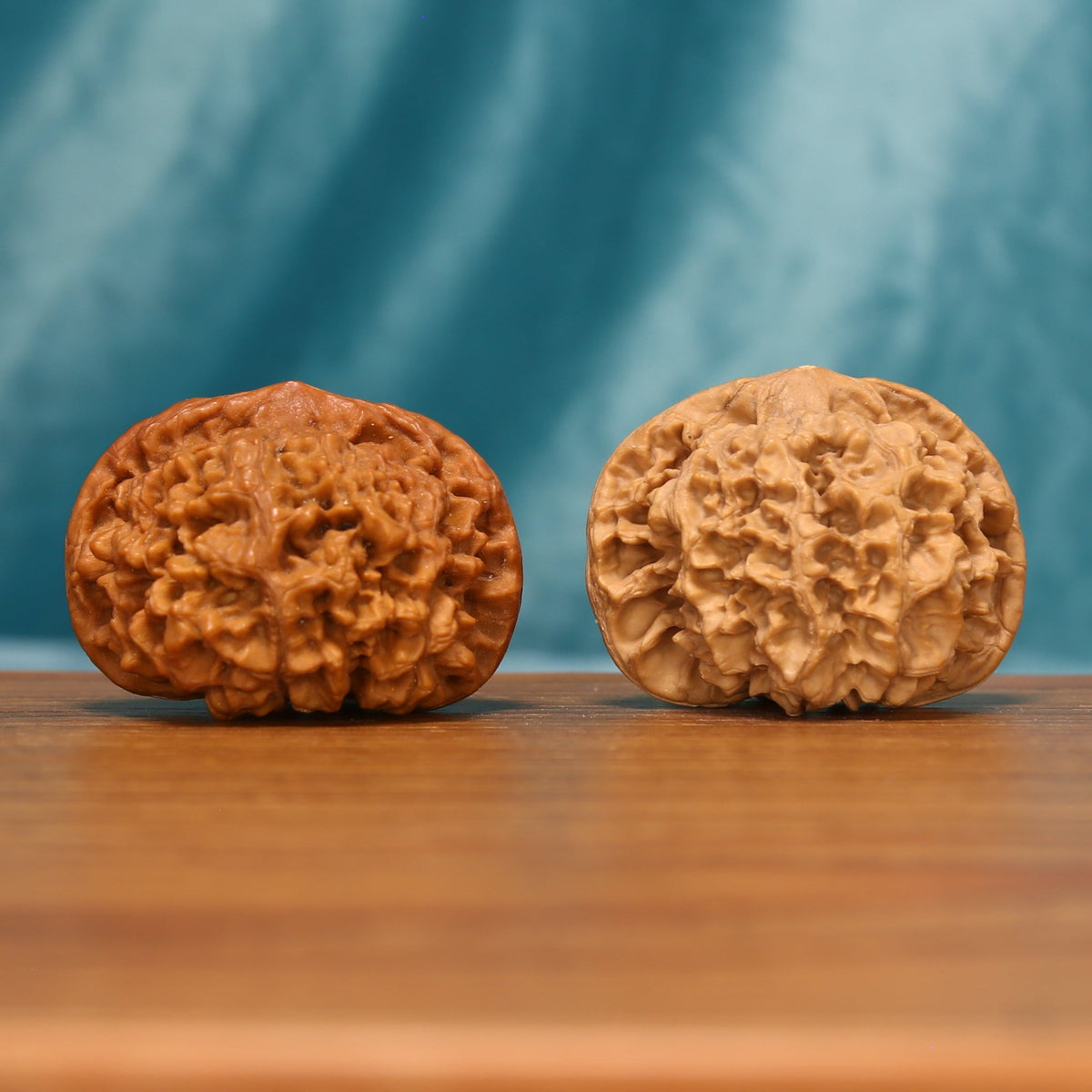 Front view of The Yin-Yang Crown Wenwan Walnut Set showing two contrasting walnuts with balanced capped forms and natural ridges.
