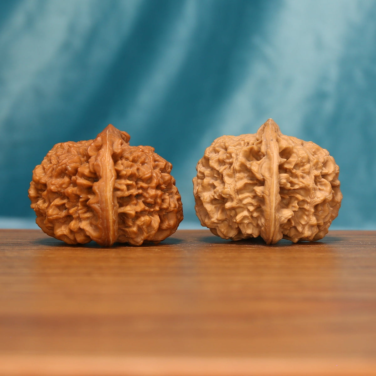 Side view of The Yin-Yang Crown Wenwan Walnut Set showing the walnuts’ capped profiles and dense textured surfaces.
