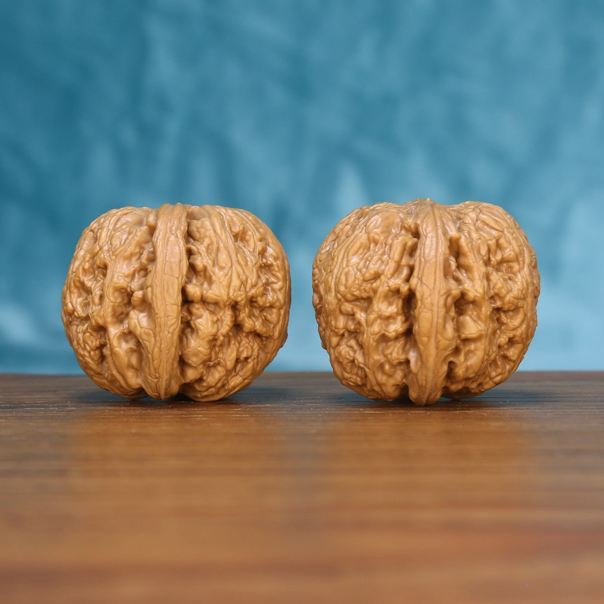 Three-quarter view of two General Wenwan walnuts showing deep sculptural ridges

