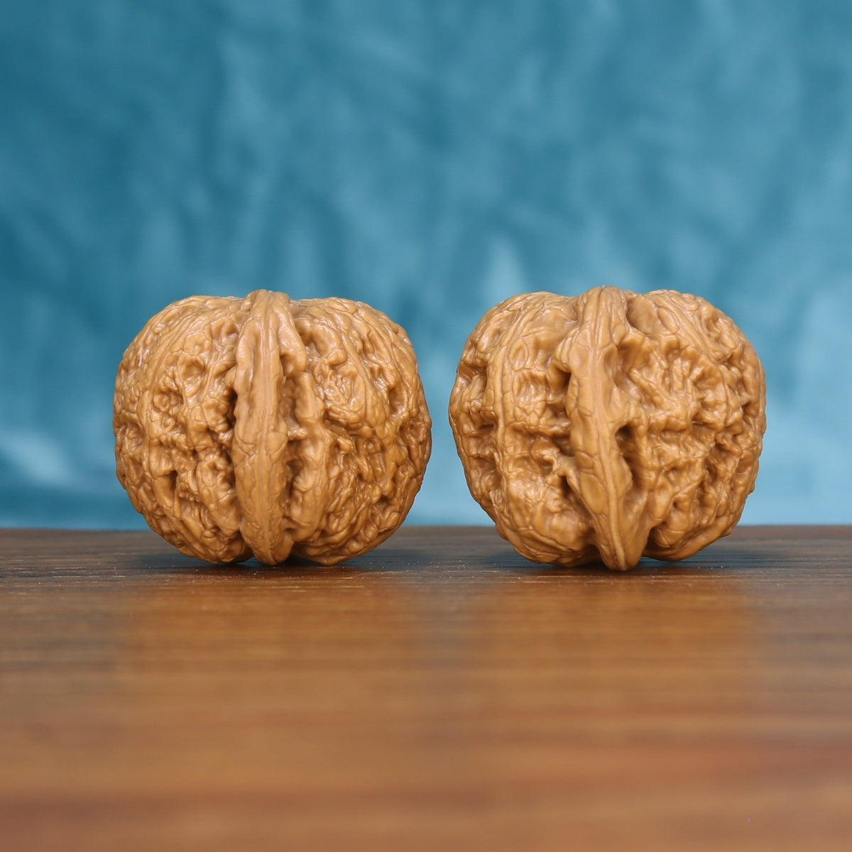 Side view of a General Wenwan walnut pair on a wooden surface
