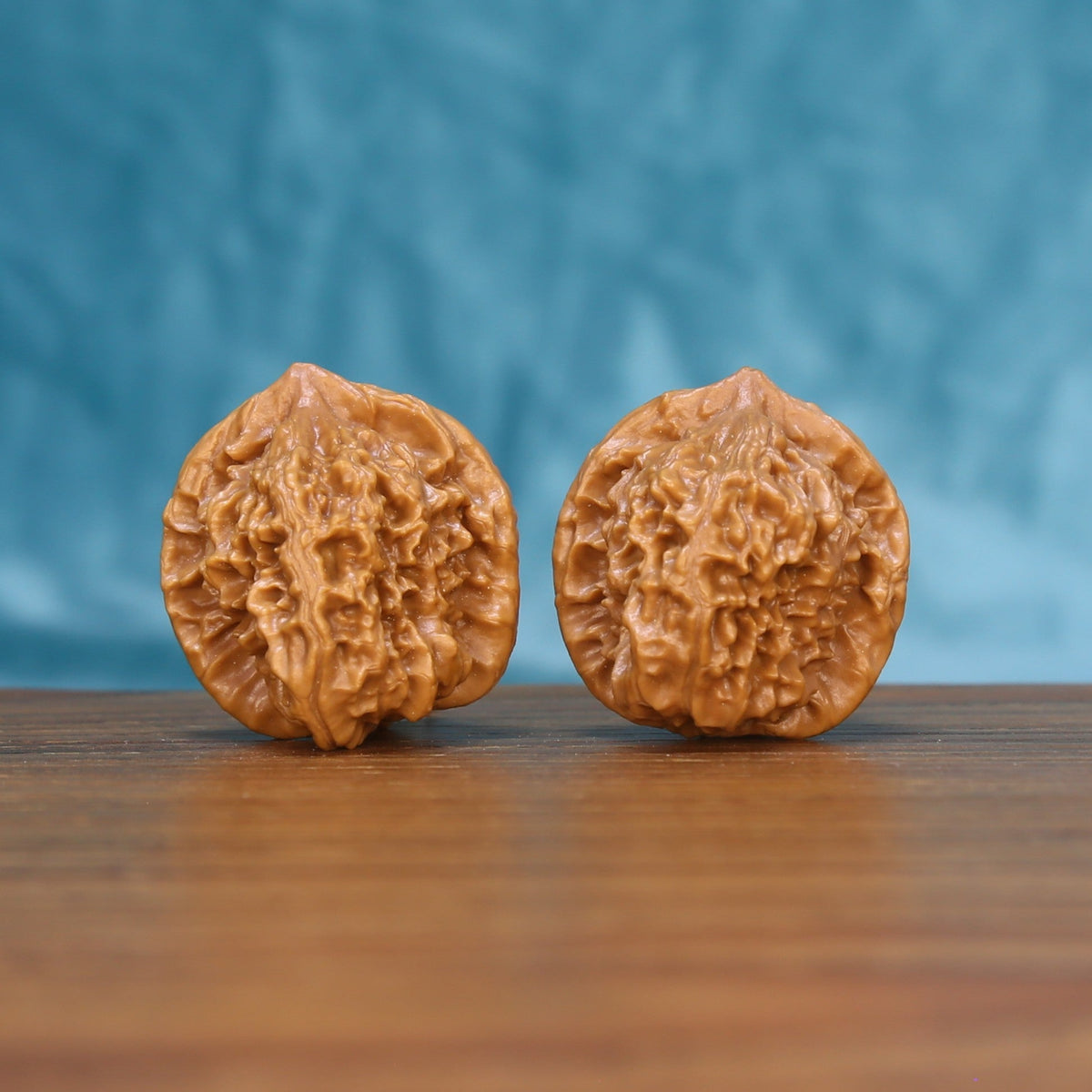 Front view of a matched pair of Qinhuangdao Wenwan walnuts with natural shell texture
