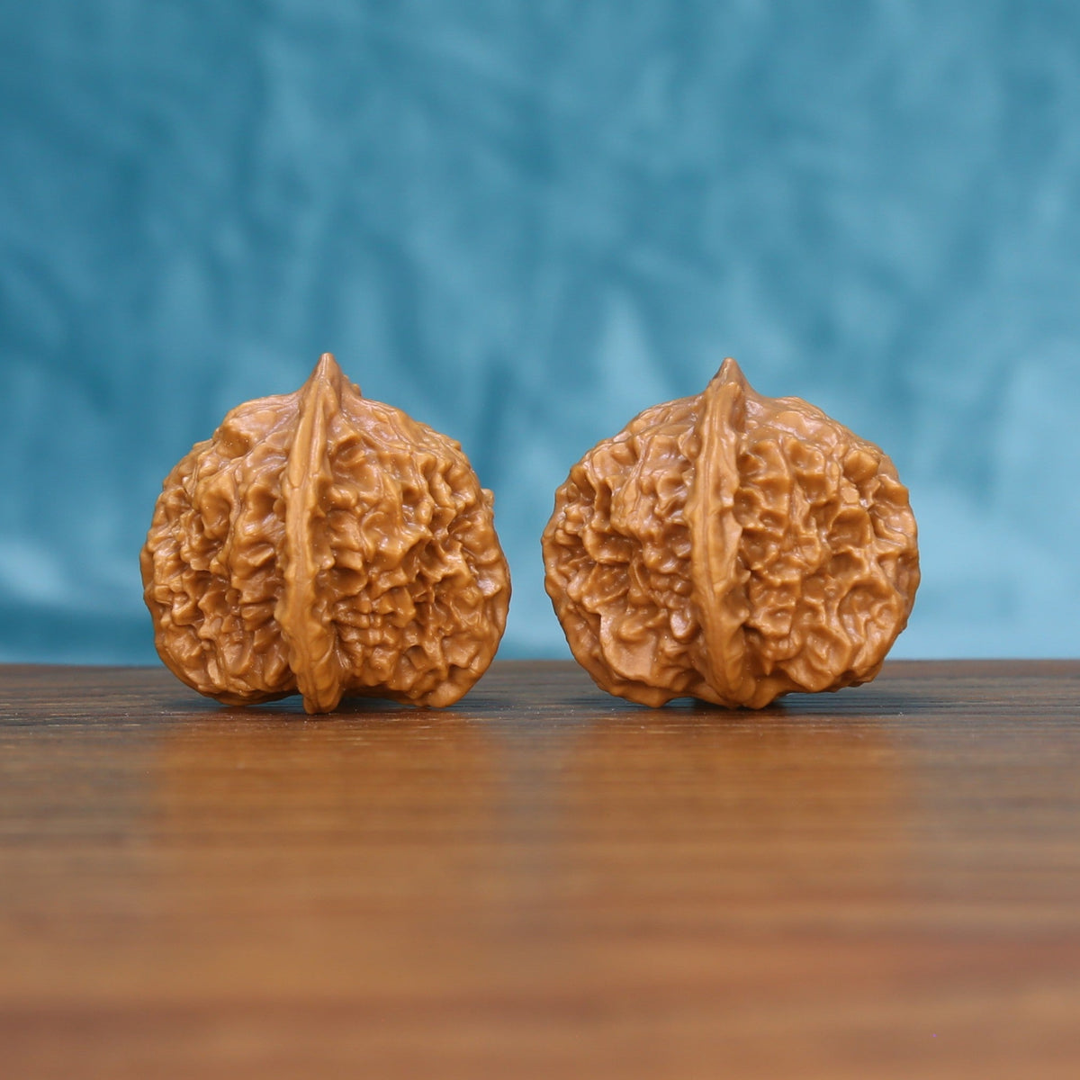 Three-quarter view of two Qinhuangdao Wenwan walnuts showing detailed natural ridges
