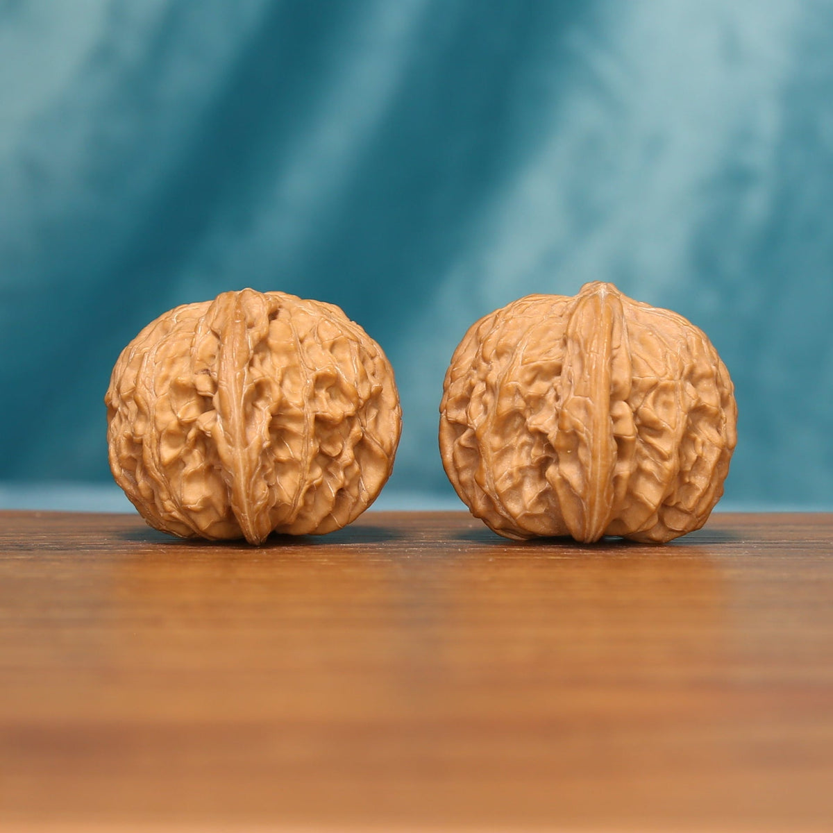 Close view of the Carved Millstones Wenwan walnut pair highlighting the natural carved ridges
