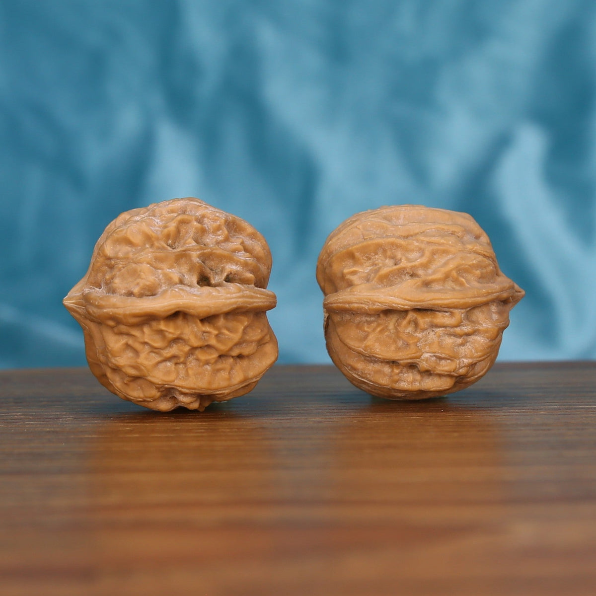 Qi-Da-Hai San-Leng walnut set side profile on wood, blue background – tri-star three-ridge geometric grain detail