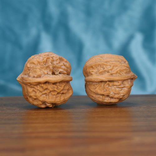 Qi-Da-Hai San-Leng walnut set side profile on wood, blue background – tri-star three-ridge geometric grain detail