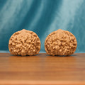 Front view of The Capstone Pair Wenwan Walnut Set showing two large rounded walnuts with capped crown forms.
