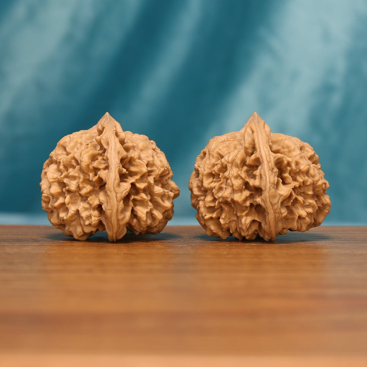 Side view of The Capstone Pair Wenwan Walnut Set showing the walnuts’ capped profiles and pronounced ridge patterns.
