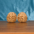 Two premium wenwan walnuts displayed on wooden surface with blue fabric background

