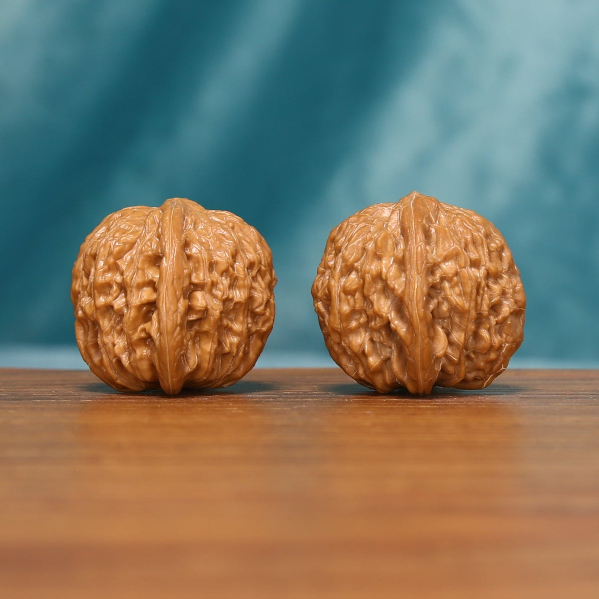 Close view of the Twin Millstones Wenwan walnut pair highlighting the natural ridge patterns
